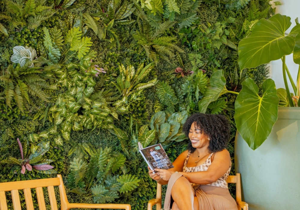 a guest reading in a green garden corner